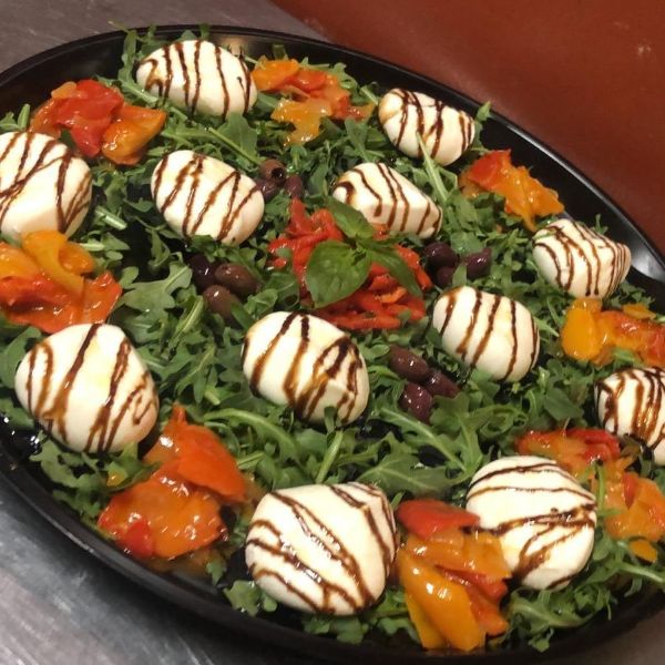 A salad with mozzarella and peppers on a plate.